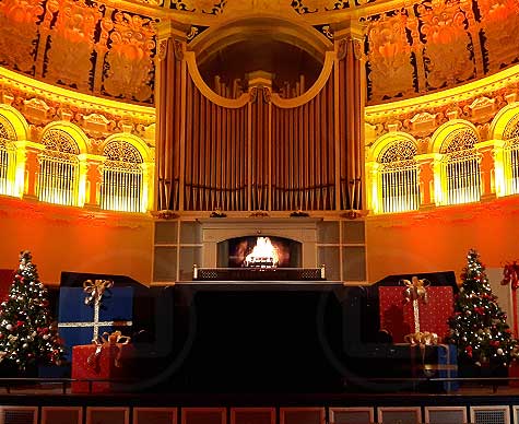 Fireplace and Christmas props on stage at Oxford Town Hall.