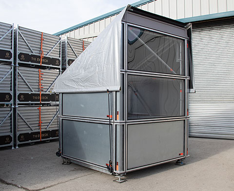 2m x 2m ground-level Control structure clad with Layher Protect wall cassettes, acrylic front windows and lockable rear door.