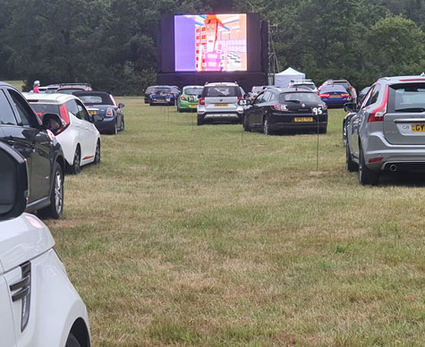 Typical Layher support structure for drive-in cinema screen on grass.